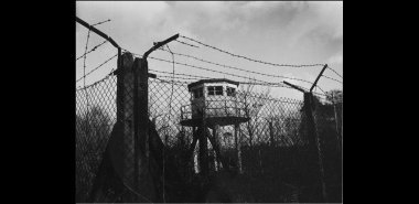 A watch tower and barbed wire create a sinister image of the Greenham Common airbase in 1969